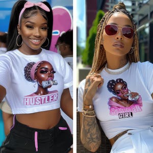 Op de afbeelding: Twee vrouwen dragen witte crop tops met een grafische print van een vrouw met geld in haar mond. De tekst op de shirts luidt "Hustler" en "Hustler Girl".