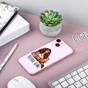 Pu&ograve; includere: Una custodia per telefono rosa con sfondo bianco e un'illustrazione di cartone animato di una donna con i capelli castani e una camicia rosa. Il testo "BOSS GIRL" &egrave; stampato in nero sulla custodia.