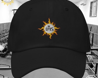May include: Black baseball cap with an embroidered sunburst design featuring the letters "IHS" in a white circle.