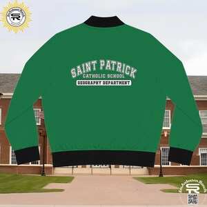 May include: Green bomber jacket with black ribbed trim. The back of the jacket features a white embroidered design that reads "Saint Patrick Catholic School Geography Department."