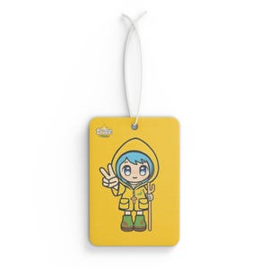 May include: Yellow car air freshener featuring a cartoon character in a yellow raincoat, holding a stick. The character has blue hair and is making a peace sign. The text "Luce" is in the top left corner.