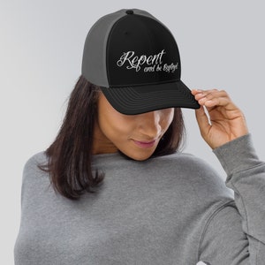 Puede incluir: Una gorra de camionero negra y gris con un diseño bordado en blanco que dice "Arrepiéntete y sé salvo".