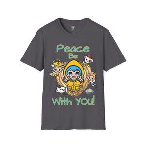 May include: Dark gray t-shirt featuring a cartoon graphic with the text "Peace Be With You!". The graphic includes a central character in a yellow hooded jacket, surrounded by other cartoon figures and a decorative frame.
