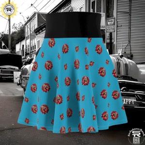 Puede incluir: Una falda de círculo azul y negro con un patrón de rosas rojas y una imagen religiosa. La falda tiene una cintura negra.