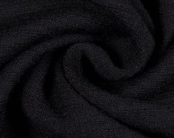 May include: Black fabric with a textured weave. The fabric is folded and draped, showing the texture and drape of the material.
