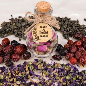 Wedding Tea Favors For Guests, Rustic Wedding Favors, Herbal Tea Favors, Loose Leaf Tea, Tea Party Favor, Bridal Shower, Wedding Guest Gifts

Delight your guests with these charming Wedding Tea Favors — a perfect blend of elegance and nature. Each favor includes a clear glass jar filled with aromatic loose-leaf herbal tea, topped with a natural cork lid and adorned with a rustic twine bow and a personalized wooden tag.