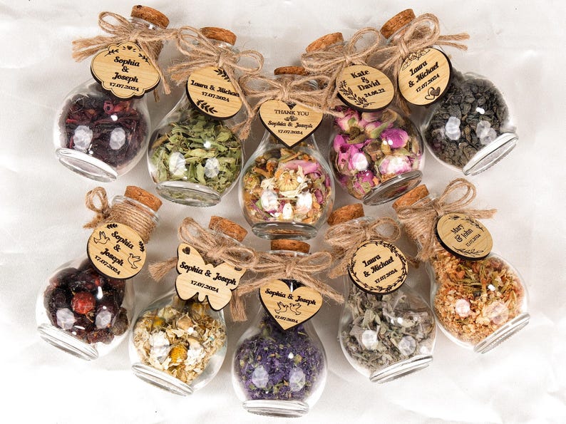 Wedding Tea Favors For Guests, Rustic Wedding Favors, Herbal Tea Favors, Loose Leaf Tea, Tea Party Favor, Bridal Shower, Wedding Guest Gifts

Delight your guests with these charming Wedding Tea Favors — a perfect blend of elegance and nature. Each favor includes a clear glass jar filled with aromatic loose-leaf herbal tea, topped with a natural cork lid and adorned with a rustic twine bow and a personalized wooden tag.