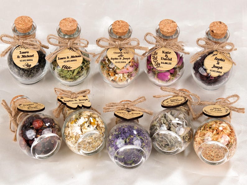 Wedding Tea Favors For Guests, Rustic Wedding Favors, Herbal Tea Favors, Loose Leaf Tea, Tea Party Favor, Bridal Shower, Wedding Guest Gifts

Delight your guests with these charming Wedding Tea Favors — a perfect blend of elegance and nature. Each favor includes a clear glass jar filled with aromatic loose-leaf herbal tea, topped with a natural cork lid and adorned with a rustic twine bow and a personalized wooden tag.