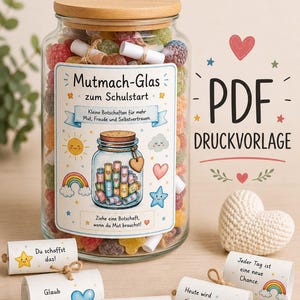 Può includere: Un barattolo di vetro trasparente con coperchio in legno riempito di caramelle gommose colorate e piccoli rotoli di carta. L'etichetta riporta il testo Mutmach-Glas zum Schulstart, illustrazioni di sole, arcobaleno e cuore, e PDF DRUCKVORLAGE.