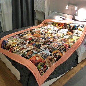 May include: A personalized photo quilt displayed on a bed. The quilt is composed of numerous individual photo squares, bordered by a peach-colored fabric. The bed is covered with a dark gray bedspread.