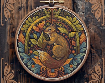 May include: Counted cross-stitch pattern featuring a squirrel surrounded by autumn leaves and flowers in a circular frame. The pattern is in shades of brown, orange, yellow, blue, and green. "Counted cross-stitch pattern by StitchingLand ©" is written below the frame.