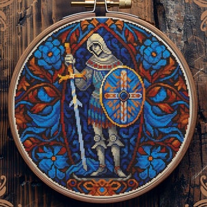 May include: Counted cross-stitch pattern of a knight in blue and gold armour, holding a sword and shield, standing in a stained glass window design. The pattern is framed in a wooden hoop.