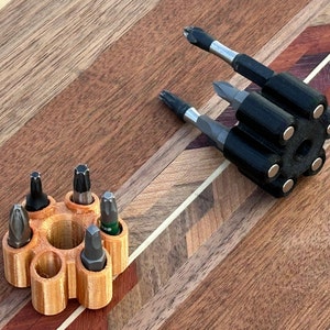May include: Two different types of magnetic screwdriver holders. One is a black holder with six slots for screwdrivers. The other is a brown holder with eight slots for screwdrivers.