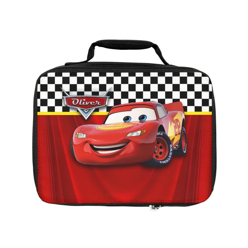 Puede incluir: Una bolsa de almuerzo roja y negra con Rayo McQueen de la pel&iacute;cula Cars. La bolsa tiene un asa y cremallera negras, con un patr&oacute;n de bandera a cuadros en la parte superior. El nombre "Oliver" est&aacute; impreso en la bolsa.