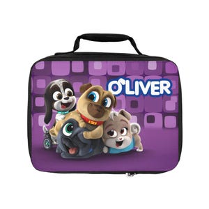 Puede incluir: Una bolsa de almuerzo morada con cachorros de dibujos animados y el nombre "OLIVER" en blanco. La bolsa tiene un asa y cremallera negras, y los cachorros son negros, marrones y grises. Ideal para niños.