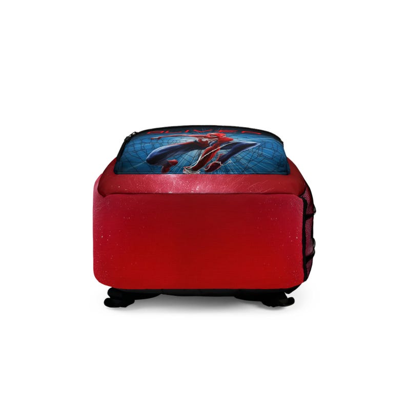 May include: Red backpack with a blue top panel featuring a graphic of a superhero in flight. The backpack has black straps and a black base. The superhero is wearing a red and blue suit.