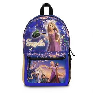 May include: A blue backpack featuring a princess design with the name "Sophia" in gold script. The backpack has a black handle and a front pocket with a zipper. The design includes a princess, a frog, and a horse.