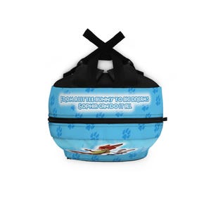 May include: A light blue backpack with a cartoon airplane design. The backpack features the text "FROM A LITTLE BUNNY TO BIG DREAMS SOPHIA CAN DO IT ALL" and paw print patterns. The straps and top are black.