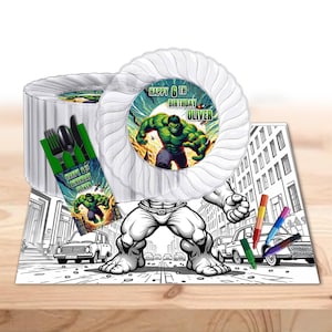 May include: Hulk themed party supplies featuring a green and black Hulk character on a white paper plate, a green and black Hulk character on a white paper napkin, and a black and white coloring placemat with crayons. The placemat features a Hulk character and the text "Happy 6th Birthday Oliver".