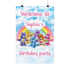May include: A poster with a blue sky background and a rainbow. The poster features several cartoon bears in various colors. The text "Welcome to Sophia's birthday party" is displayed in pink.