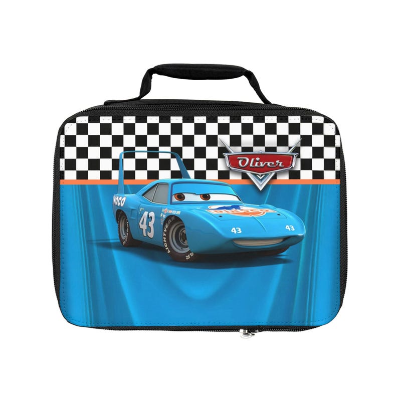Puede incluir: Una bolsa de almuerzo azul con un coche de carreras de dibujos animados, el n&uacute;mero 43. La bolsa tiene un asa negra y un patr&oacute;n de cuadros blanco y negro en la parte superior. El nombre "Oliver" se muestra en la bolsa.