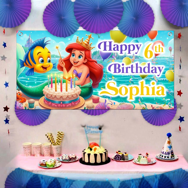 May include: A colourful birthday banner featuring Ariel from The Little Mermaid, a yellow fish, and a cake with candles. The banner says "Happy 6th Birthday Sophia".
