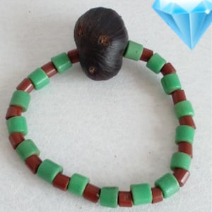 May include: A brown wooden bead bracelet with green glass beads. The bracelet is made of alternating brown and green beads.