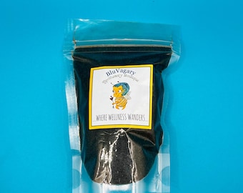 May include: A clear plastic bag filled with black loose leaf tea. The bag has a label that says "BluVagary Apothecary Boutique" and "...where wellness wanders..." with a cartoon bee illustration.