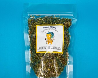 Può includere: Un sacchetto di plastica trasparente pieno di erbe secche. Il sacchetto ha un'etichetta che dice "Blu Vagary Apothecary Boutique" e "...dove il benessere vaga..." L'etichetta presenta un'ape di cartone animato con un cappello blu.