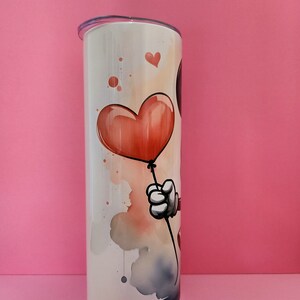 May include: White stainless steel tumbler with a watercolor design of a cartoon character holding a red heart-shaped balloon.