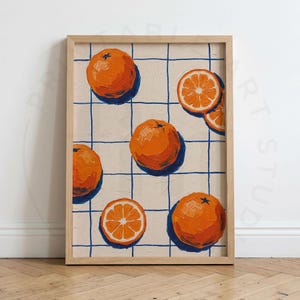 Pode incluir: Uma pintura emoldurada apresentando um padrão de grade com linhas azuis finas sobre um fundo bege claro. A obra exibe várias frutas cítricas de cor laranja brilhante, incluindo laranjas inteiras e metades, com pinceladas visíveis.