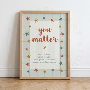 Pode incluir: Uma impressão artística emoldurada com fundo de grade verde claro e uma borda de pequenas estrelas vermelhas, amarelas e verde-azuladas. O texto diz: you matter. Your ideas, your voice, and your kindness make a difference. A moldura é de madeira clara.