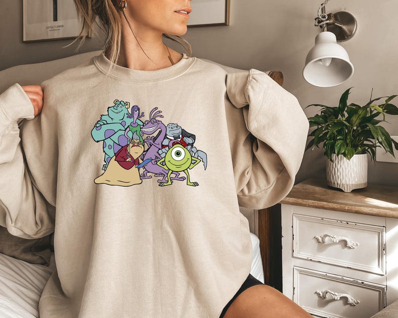 Puede incluir: Sudadera beige de cuello redondo con un gr&aacute;fico colorido de personajes de la pel&iacute;cula animada Monstruos, S.A. El gr&aacute;fico incluye a Mike Wazowski, Sulley y otros monstruos. La sudadera est&aacute; hecha de un material suave.