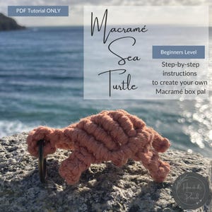 Puede incluir: Una tortuga marina de macramé hecha a mano en tono coral, con un anillo de metal. La imagen incluye el texto "Macramé Sea Turtle" y "Beginners Level". El tutorial es para crear un macramé box pal.