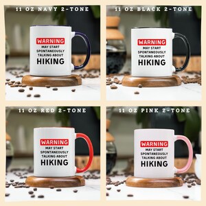 May include: Four white ceramic mugs with coloured handles and rims, each with the text "WARNING MAY START SPONTANEOUSLY TALKING ABOUT HIKING." The mugs are navy, black, red, and pink, and are displayed on wooden coasters.