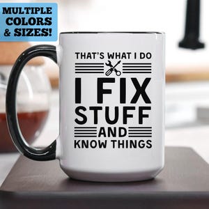 May include: White ceramic mug with a black handle and rim. The mug features the text "THAT'S WHAT I DO, I FIX STUFF AND KNOW THINGS" in black, along with a wrench and screwdriver graphic. The top left corner has a blue rectangle with "MULTIPLE COLORS & SIZES!"