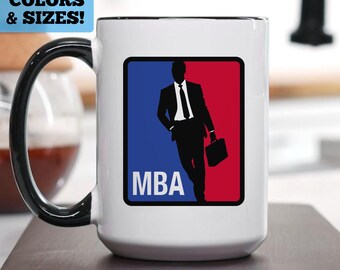 May include: White ceramic coffee mug with a black rim and handle. The mug features a graphic of a silhouette of a person in a suit holding a briefcase, standing in front of a red and blue background with the word "MBA" in white letters.