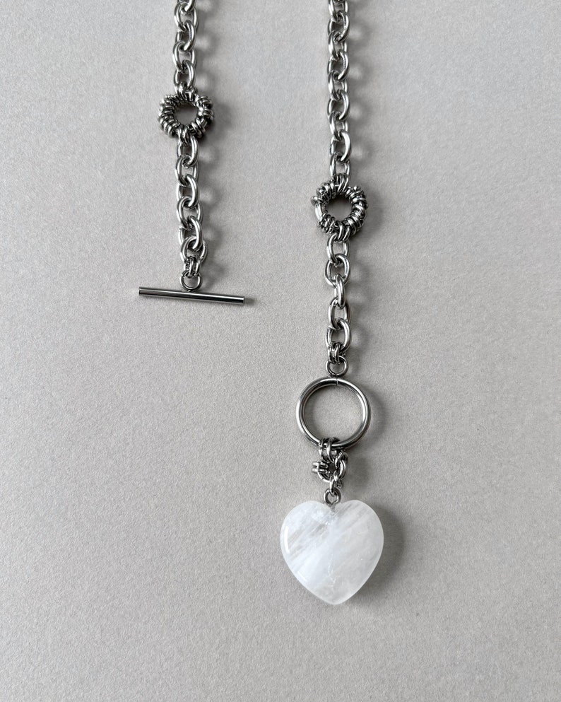 The statement necklace features a clear quartz pendant and toggle clasp.
