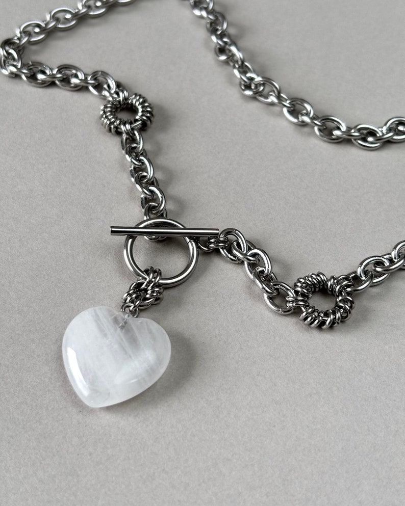 The crystal pendant made from clear quartz and chunky chain makes this piece of jewelry bold and edgy.
