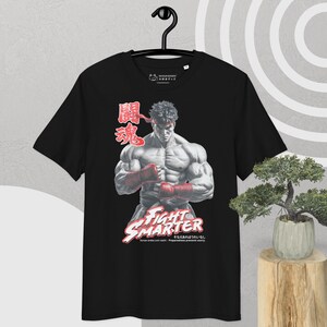 Puede incluir: Camiseta negra con un luchador musculoso con guantes y diadema rojos. El diseño incluye caracteres japoneses y las palabras "FIGHT SMARTER". A la derecha hay un pequeño bonsái.