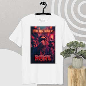 May include: White t-shirt featuring a graphic of three monkeys in a neon-lit setting. The design includes the text "THREE WISE MONKEYS" and "SEE, HEAR, SPEAK NO EVIL" in English and Japanese. The shirt is hanging on a black hanger.