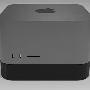 May include: A gray, rectangular computer with a black base and an Apple logo on the top. It has two small ports and a long slot on the front.