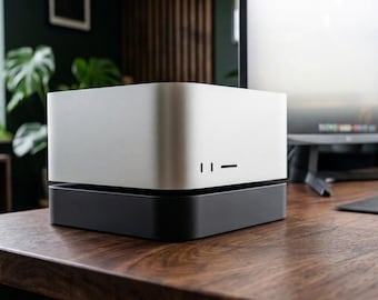May include: A compact, square-shaped computer tower featuring a two-tone design with a silver metallic upper section and a matte black base. The front panel includes two vertical ports and a horizontal slot, providing a clean and functional aesthetic.