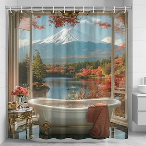 May include: A shower curtain featuring a scenic view of a mountain, lake, and autumn foliage. The image shows a white bathtub with gold accents, a side table with flowers, and a window frame.