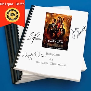 May include: A white notebook with a black spiral binding. The notebook features a movie poster for the film "Babylon" by Damien Chazelle. The poster features Brad Pitt and Margot Robbie. The notebook also has a handwritten signature that says "Jean Smart".