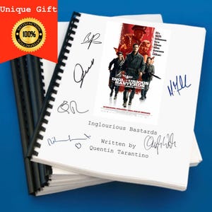 May include: A white notebook with a movie poster for the film "Inglourious Basterds" on the cover. The poster features Brad Pitt and Michael Fassbender. The notebook has several signatures on the cover, including Quentin Tarantino's.