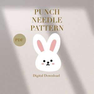 Puede incluir: Un patrón de aguja perforadora de descarga digital con un conejito blanco con orejas internas rosas y mejillas rosadas. El texto "PUNCH NEEDLE PATTERN" es dorado, con "PDF" en un círculo y "Descarga Digital".