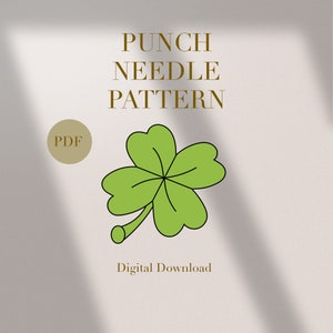 Puede incluir: Un patrón de bordado con aguja de punzón para un trébol de cuatro hojas, disponible para descarga digital en formato PDF. El patrón presenta un trébol verde con un tallo marrón y un círculo marrón con la palabra "PDF" en él.