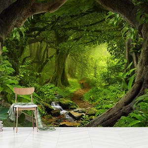 May include: A vibrant jungle scene with a winding path, a small stream, and a wooden chair. The image features a lush display of foliage, with large trees framing the view. A stack of books and a decorative vase are in the foreground.