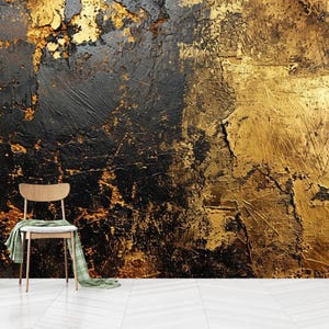 Könnte beinhalten: Eine texturierte Wand mit einem abstrakten Design in Schwarz und Gold. Ein Holzstuhl mit einem grünen karierten Überwurf steht vor der Wand.